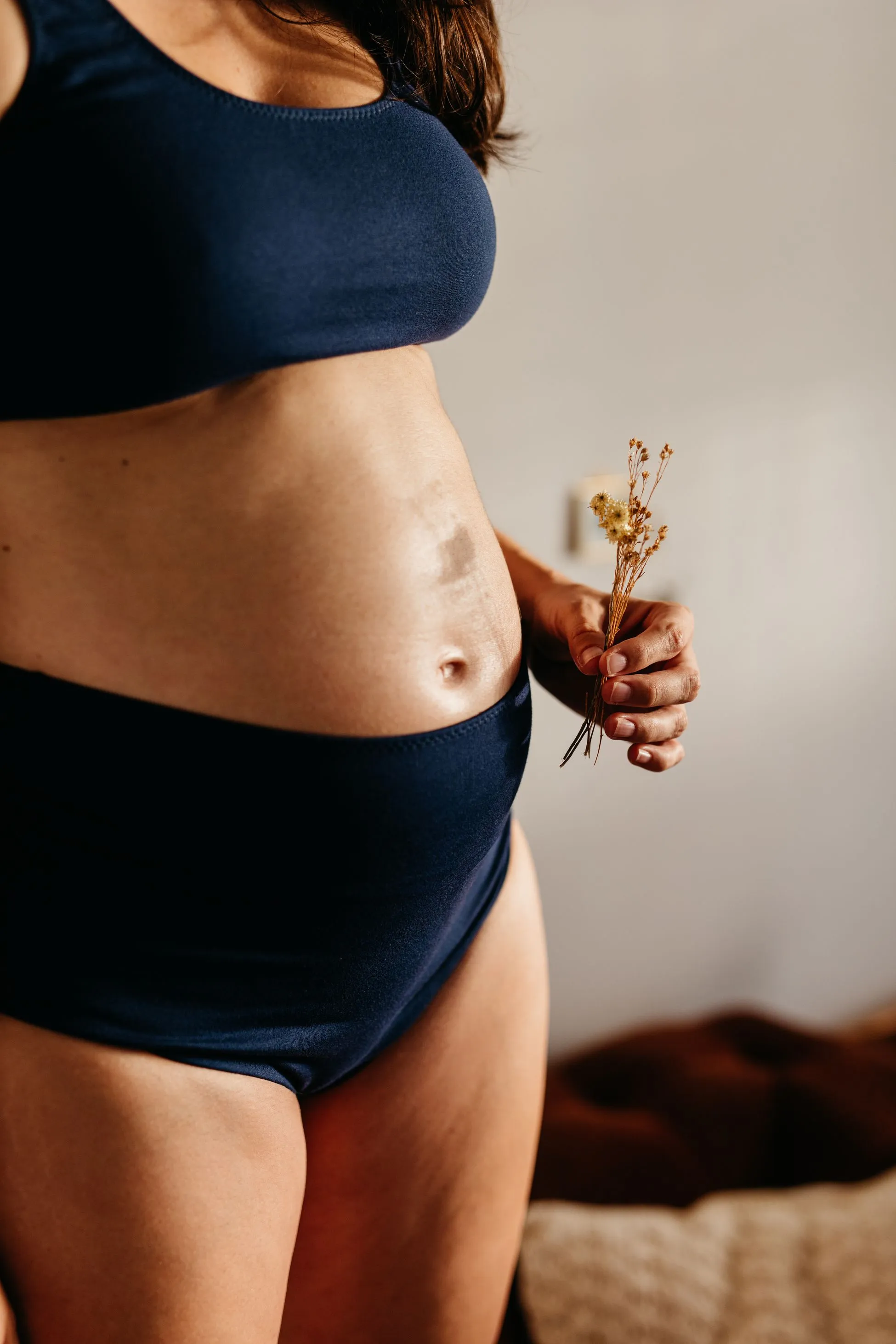 A pregnant woman holding flowers