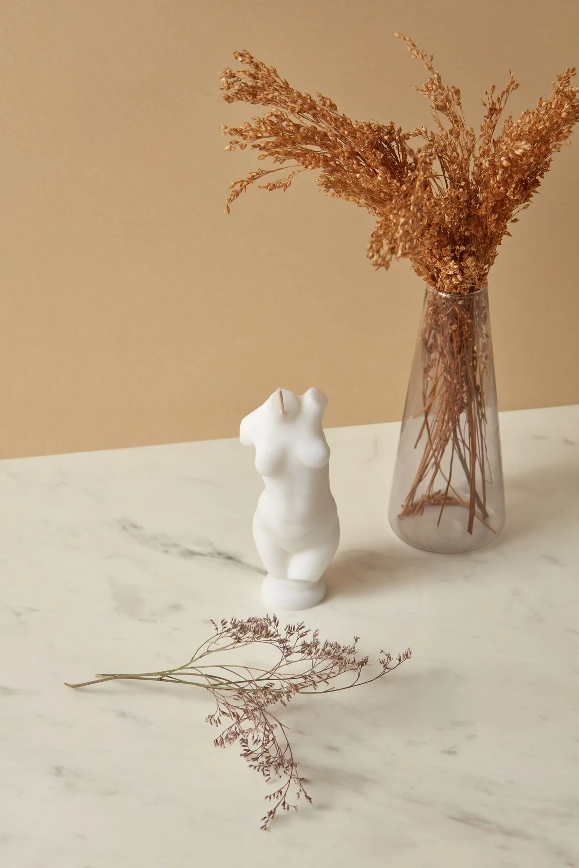 A white figurine with a vase of flowers