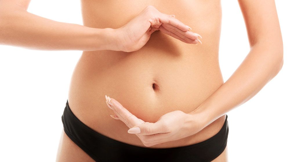 Woman holding hands around bare midriff